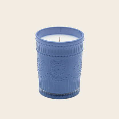 Blue embossed glass scented candle, lit flame