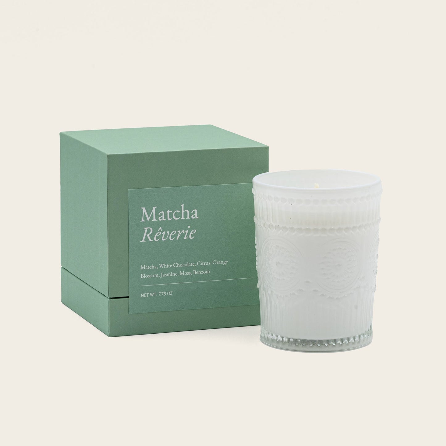 White embossed glass scented candle, lit, with green "Matcha Réverie" box