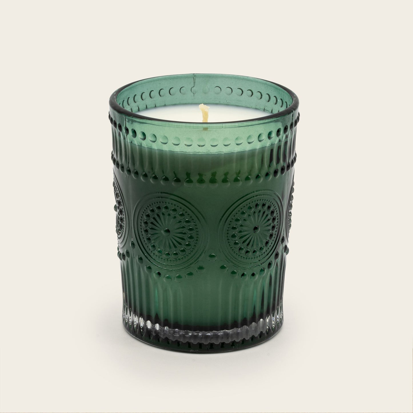 Green embossed glass scented candle, lit flame