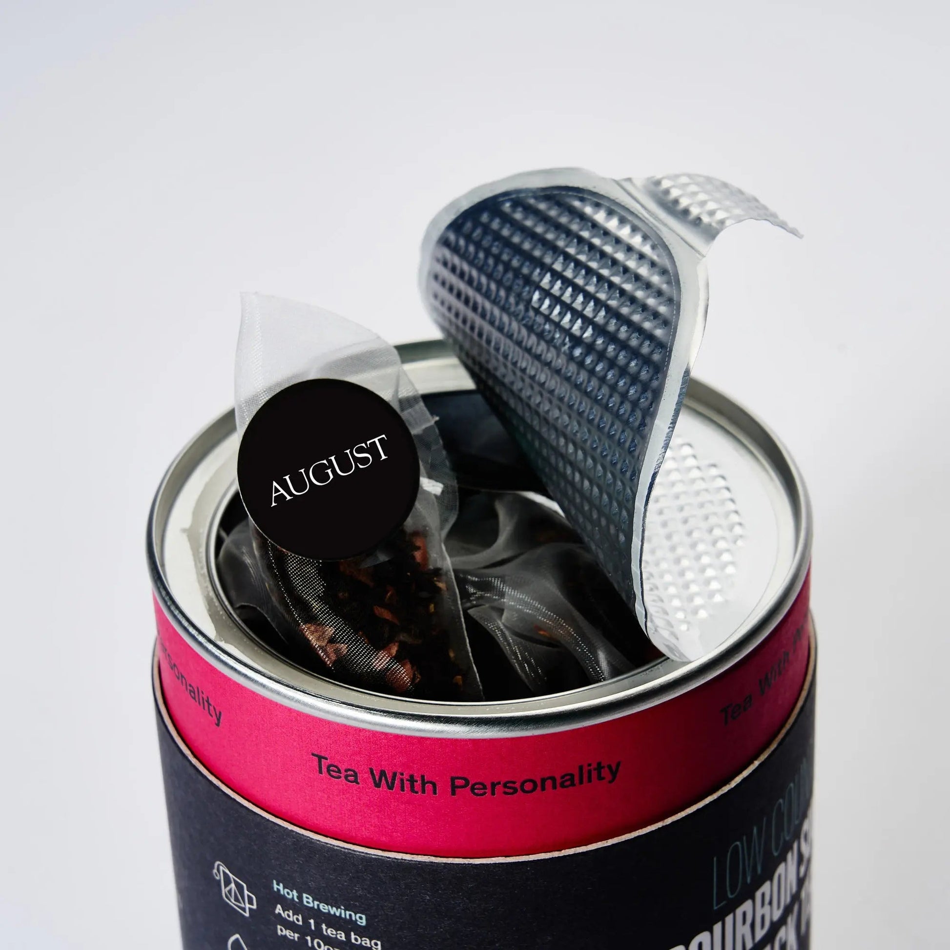 Metal tin holding pyramid tea bags with an August round seal