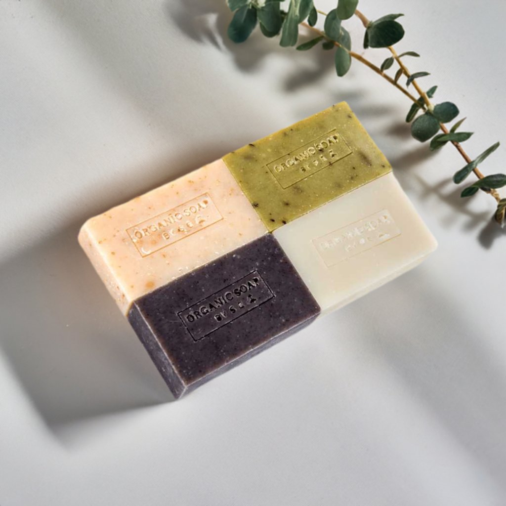 Organic bar soap bar stack with pink, olive, and cream tones, stamped label.