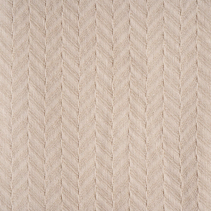 Herringbone knit cotton blanket close-up, ivory chevron pattern on textured fabric