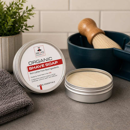 Organic shave soap tin with open cream and shaving brush on towel