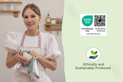 White kitchen towel with green stripes held by a woman wearing a white apron
