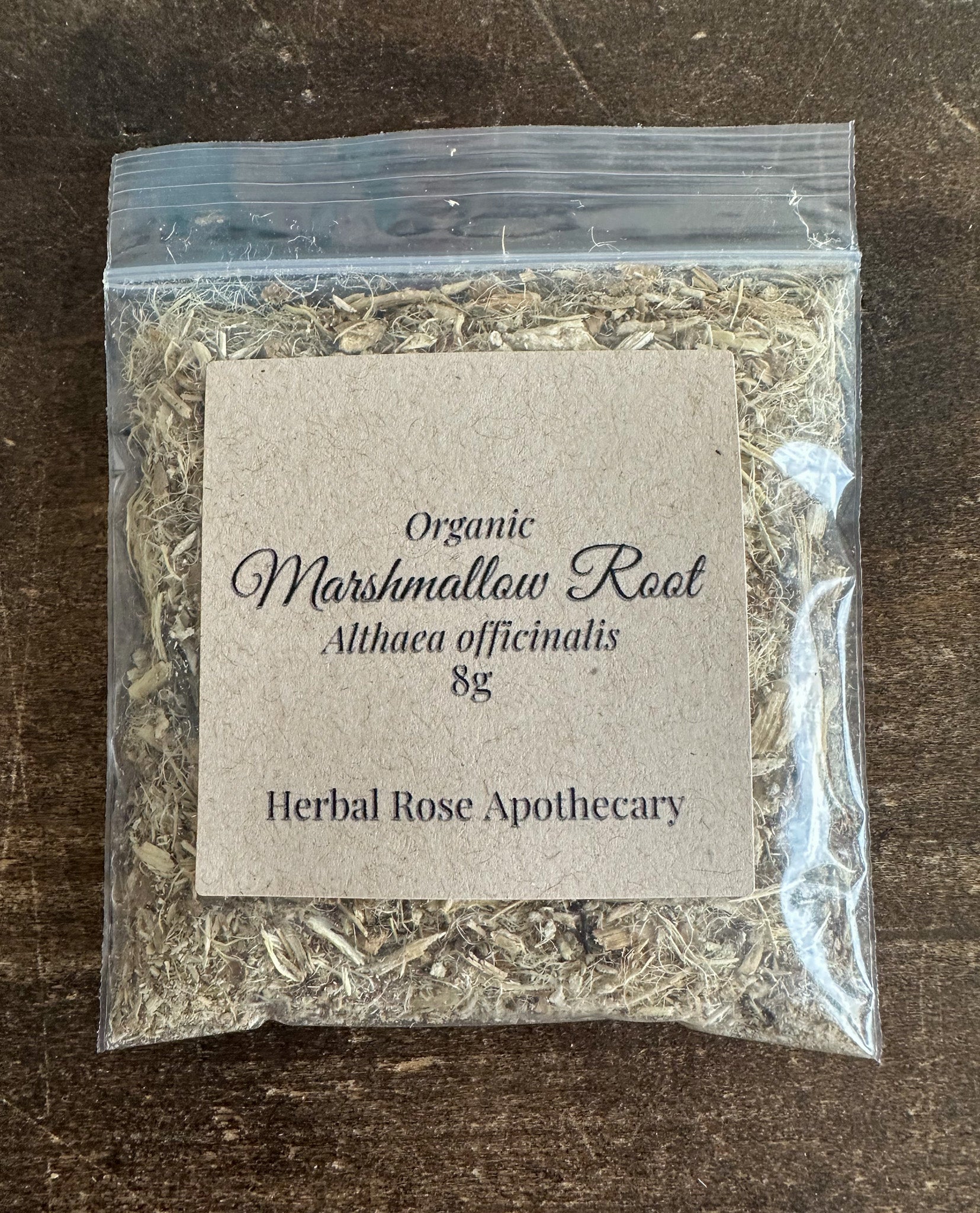 Dried marshmallow root in clear pouch with paper label, light tan shredded herb