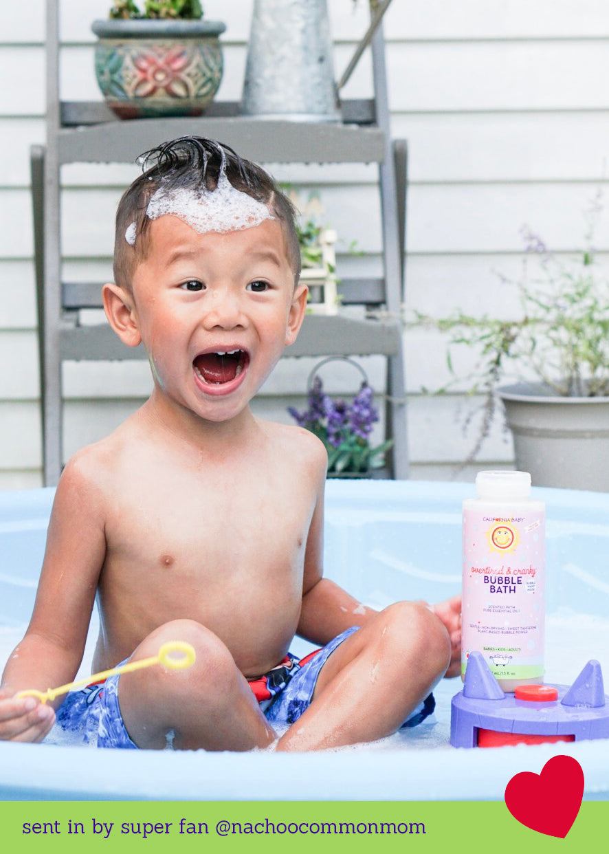 Bubble bath bottle beside laughing child in a pool