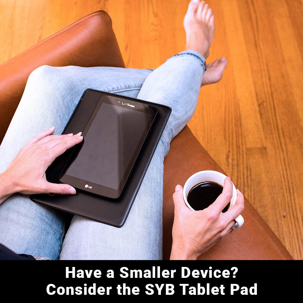 Black tablet pad with a corner logo, holding a small device on a couch.