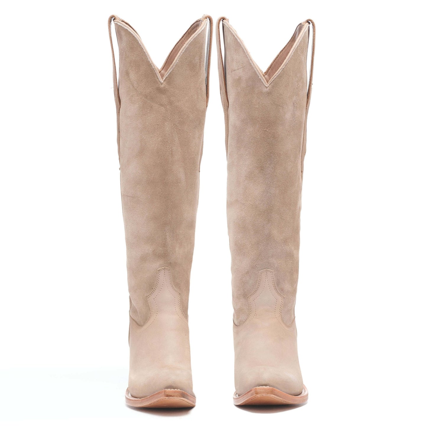 Light taupe suede cowboy boots, tall mid-calf with V-notch top and pointed toe.