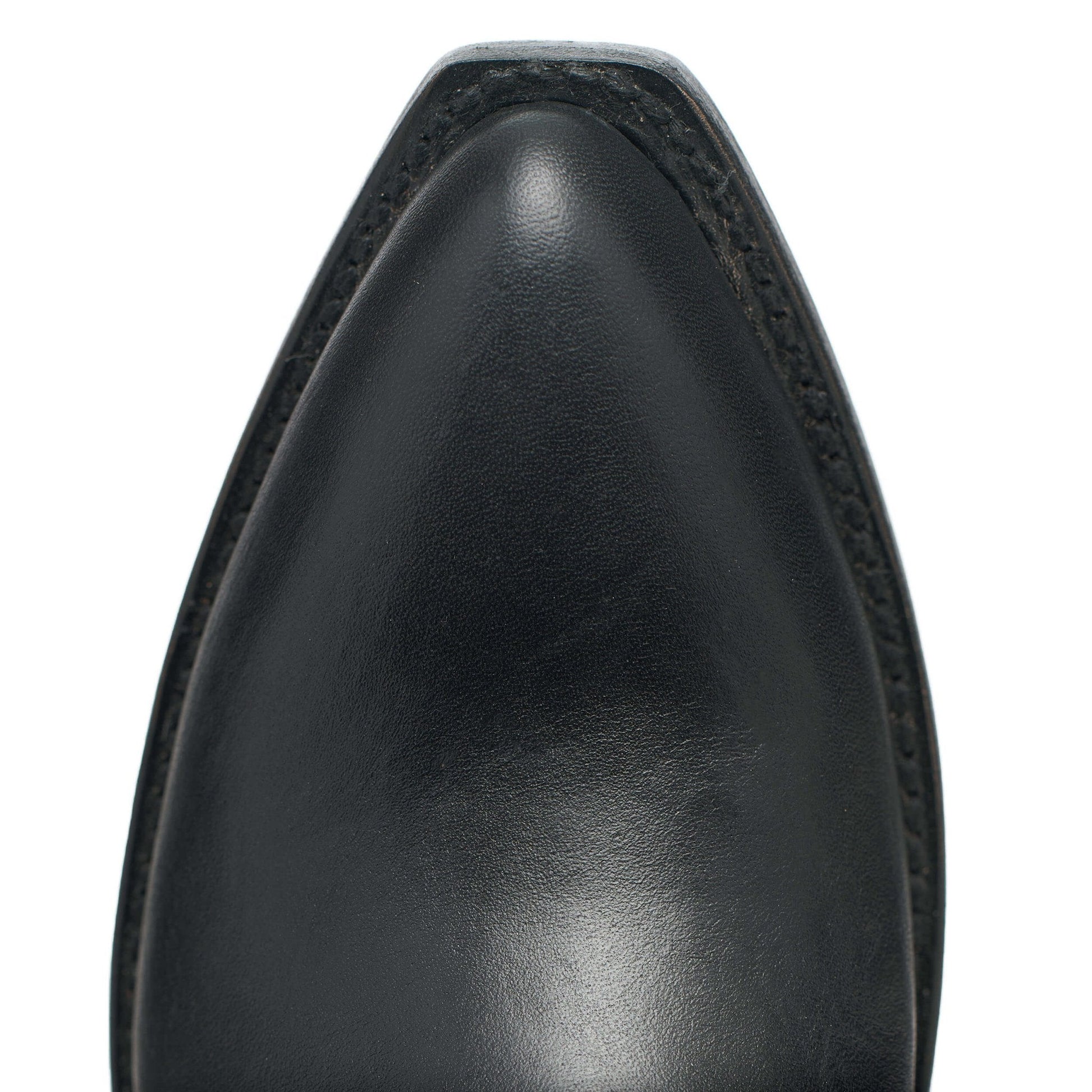 Black leather cowboy boot upper, close-up of rounded toe and stitching