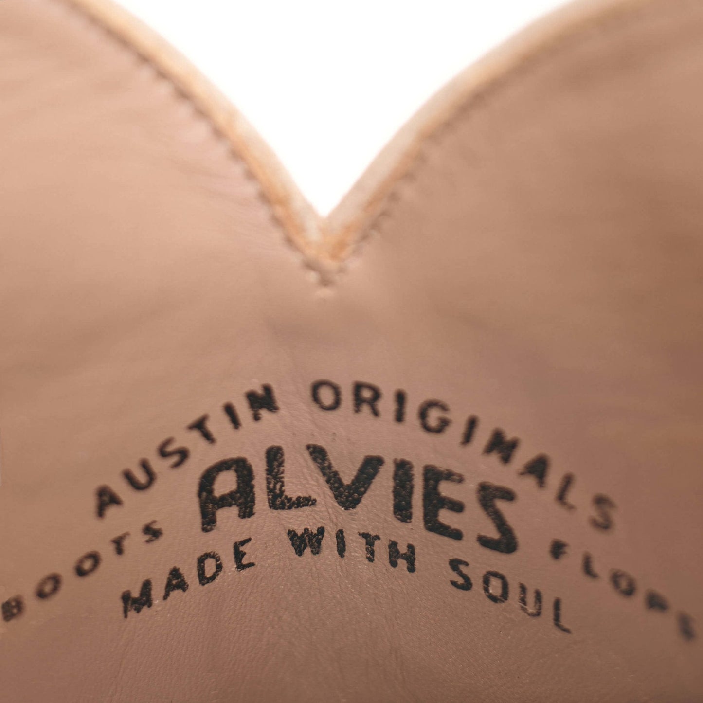 Tan leather boot insole stamp with brand lettering in dark ink.
