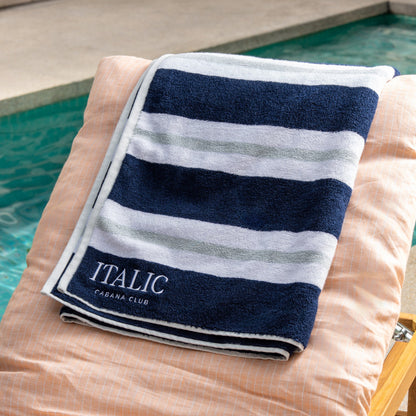 Navy and white striped cotton beach towel with stitched edge and 'ITALIC' label