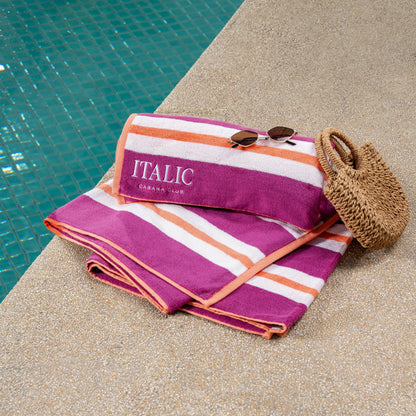 Pink and orange striped cotton beach towel with 'ITALIC' text on folded set