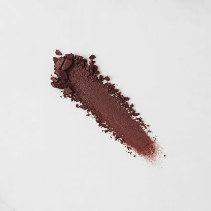 Pressed eyeshadow swatch, dark plum shimmer streak