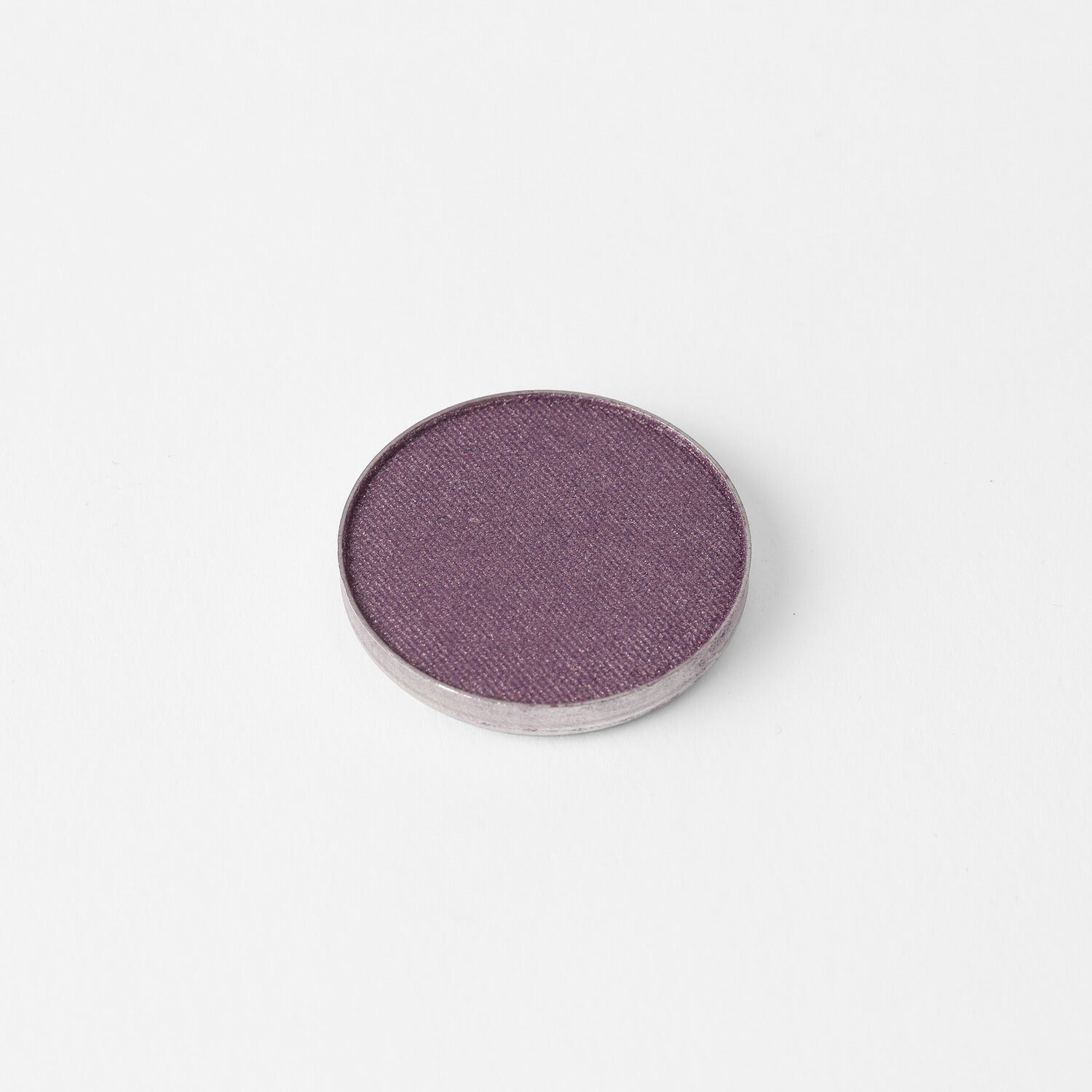 Pressed eyeshadow pan with a mauve-purple shimmer surface in a round case