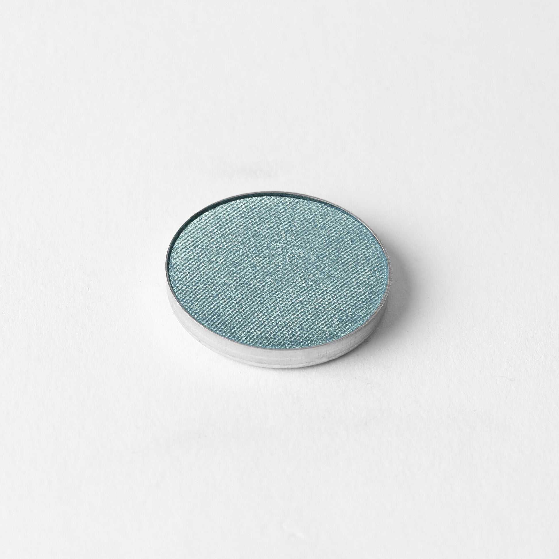 Pressed eyeshadow compact with teal-blue oval pan