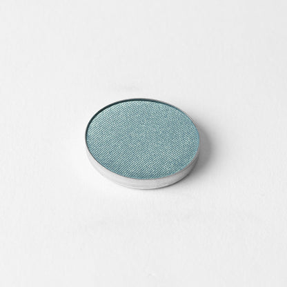 Pressed eyeshadow compact with teal-blue oval pan