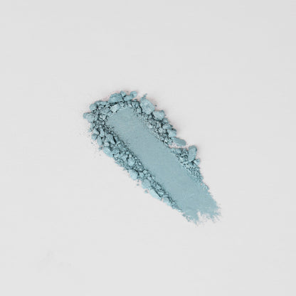 Teal pressed eyeshadow swatch with textured powder smear