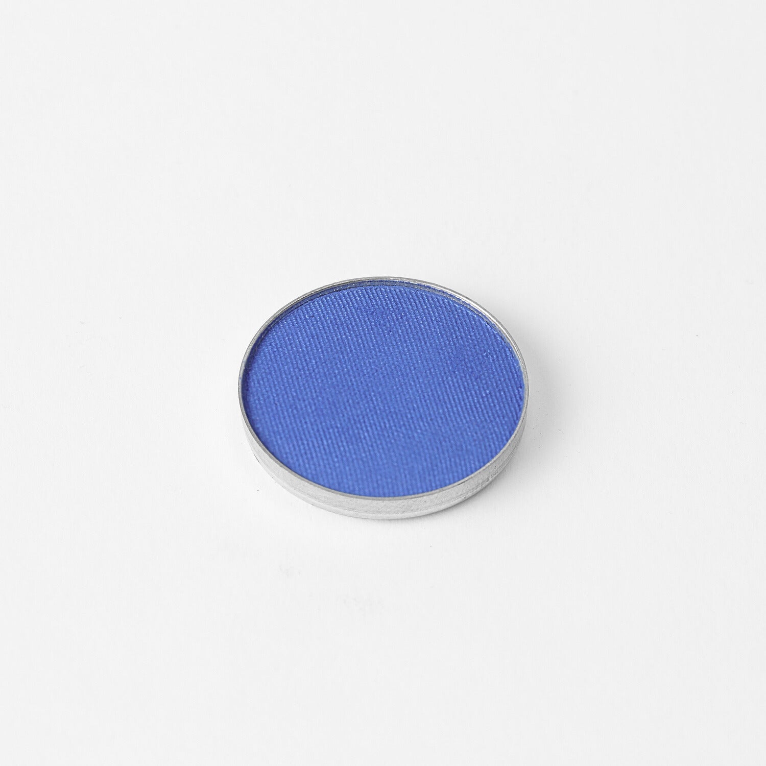 Pressed eyeshadow pan, bright blue shimmer in a round compact.