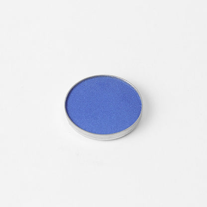 Pressed eyeshadow pan, bright blue shimmer in a round compact.