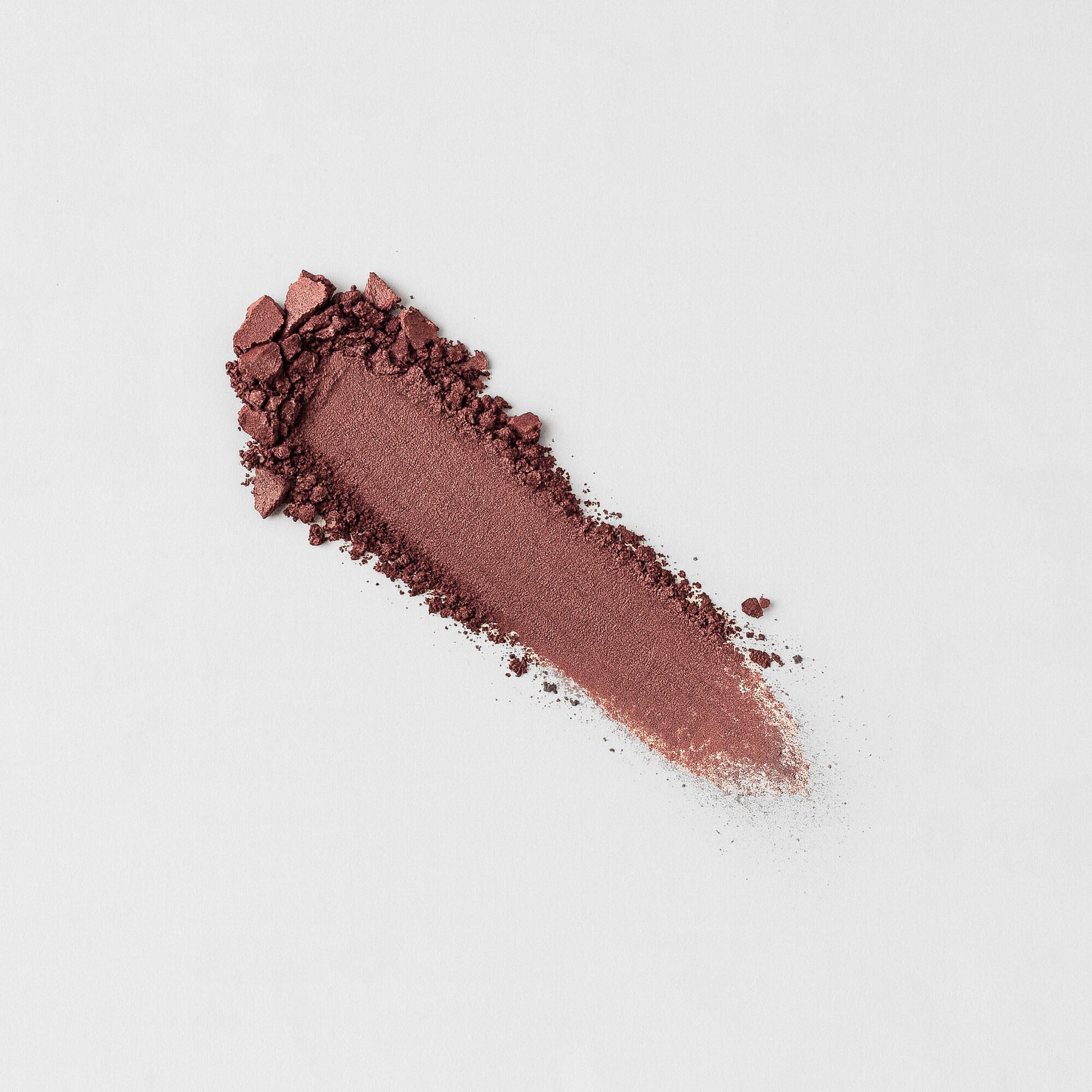 Pressed eyeshadow swatch in deep mauve-brown shimmer with textured powder edge