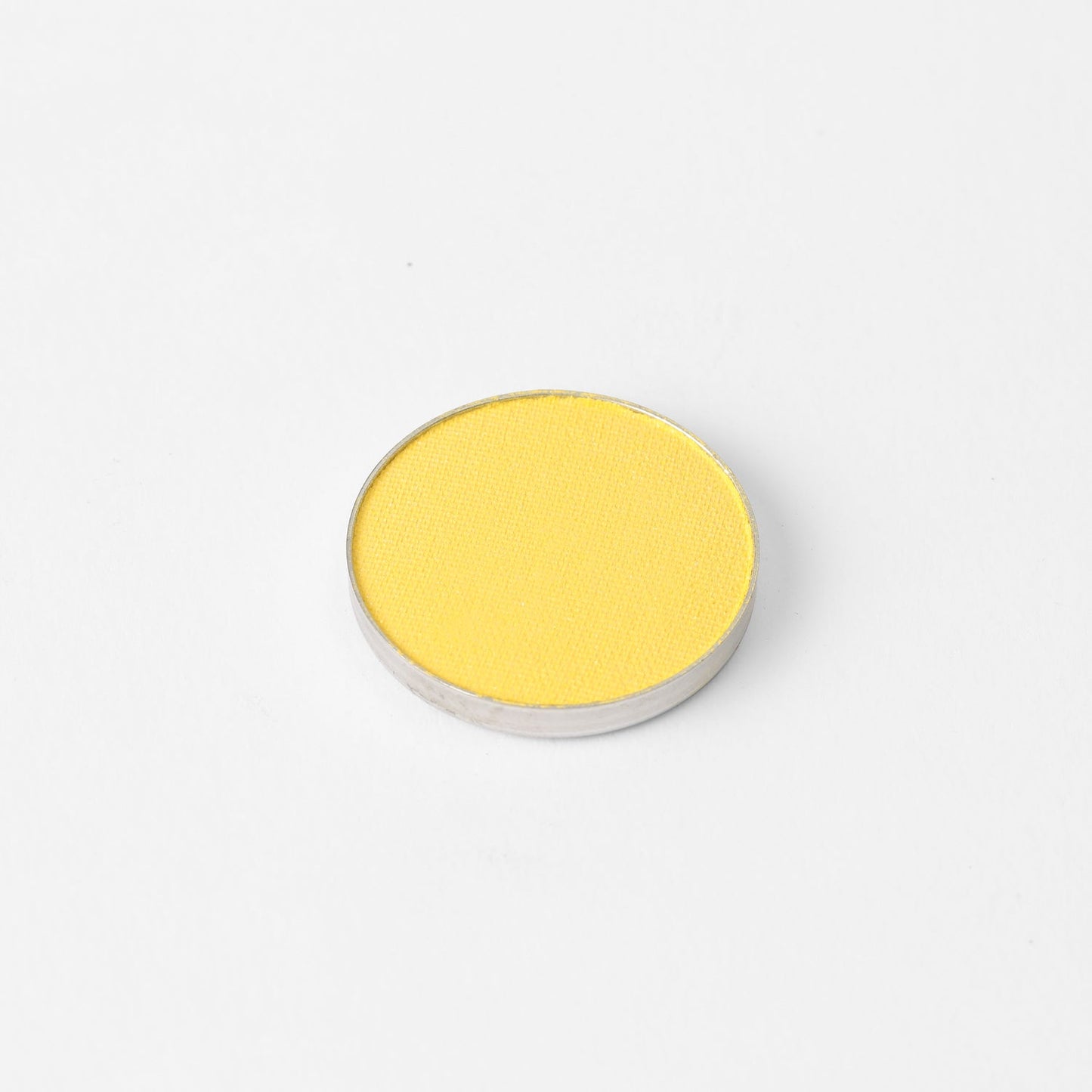 Pressed eyeshadow pan, vivid yellow shimmer