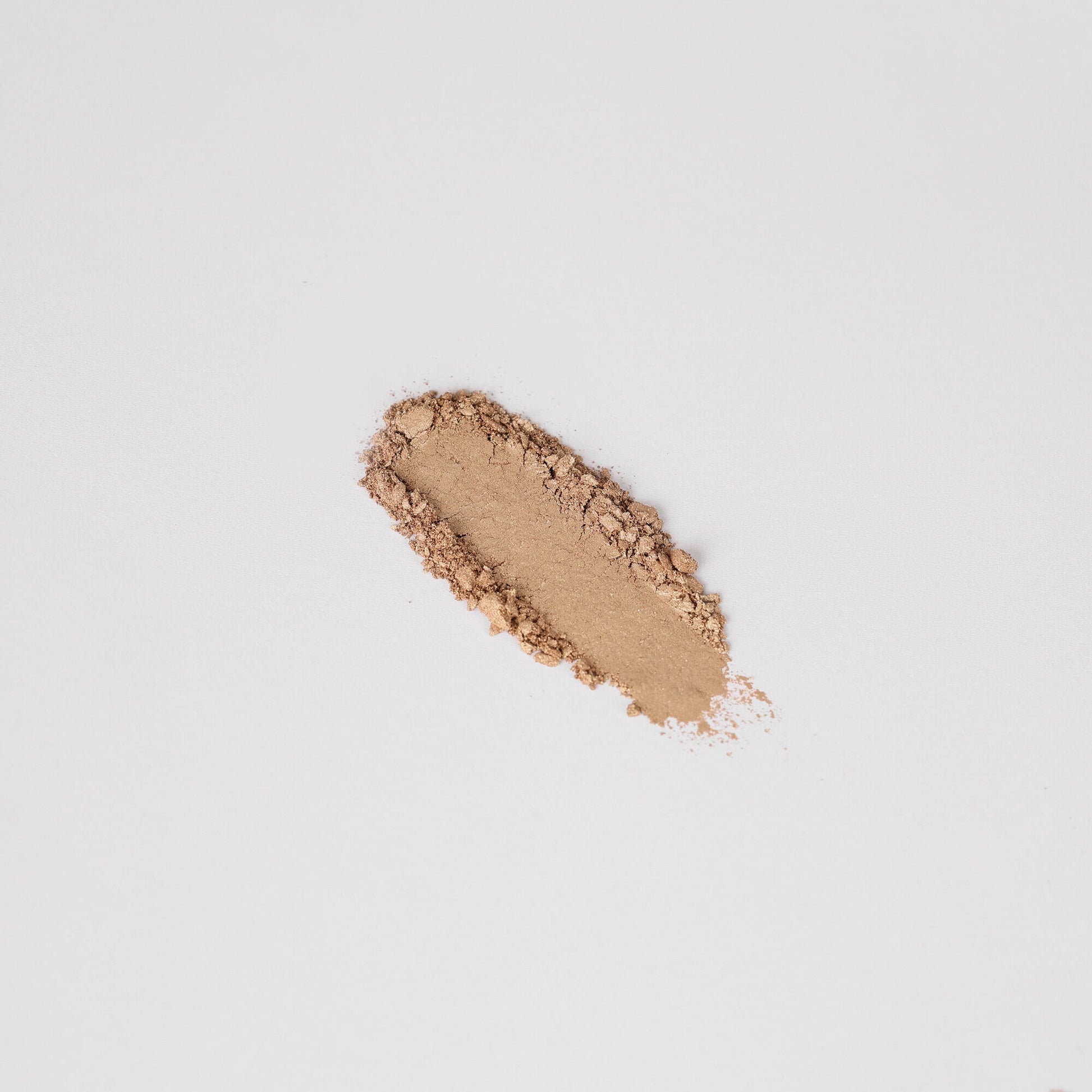 Pressed eyeshadow swatch in warm bronze shimmer with soft dusting