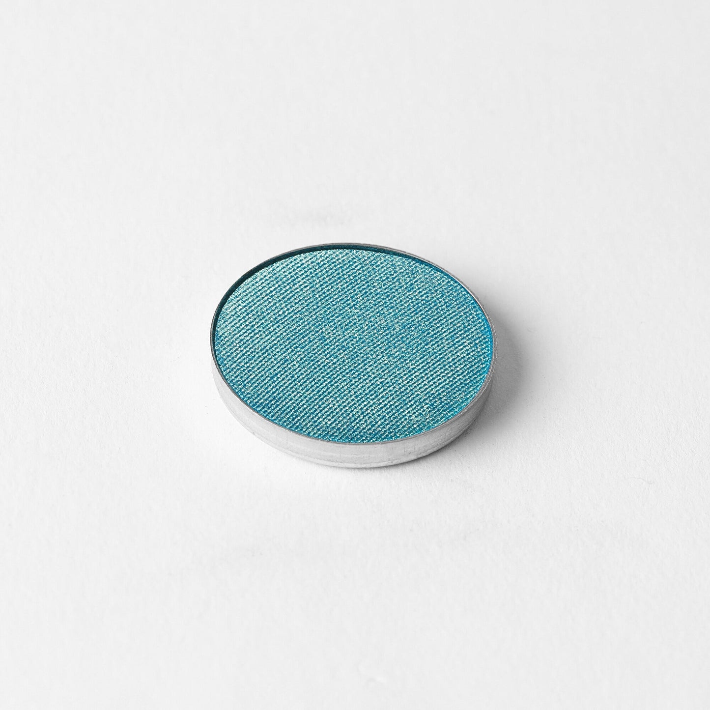 Pressed eyeshadow compact with teal-blue oval pan