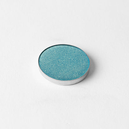 Pressed eyeshadow compact with teal-blue oval pan