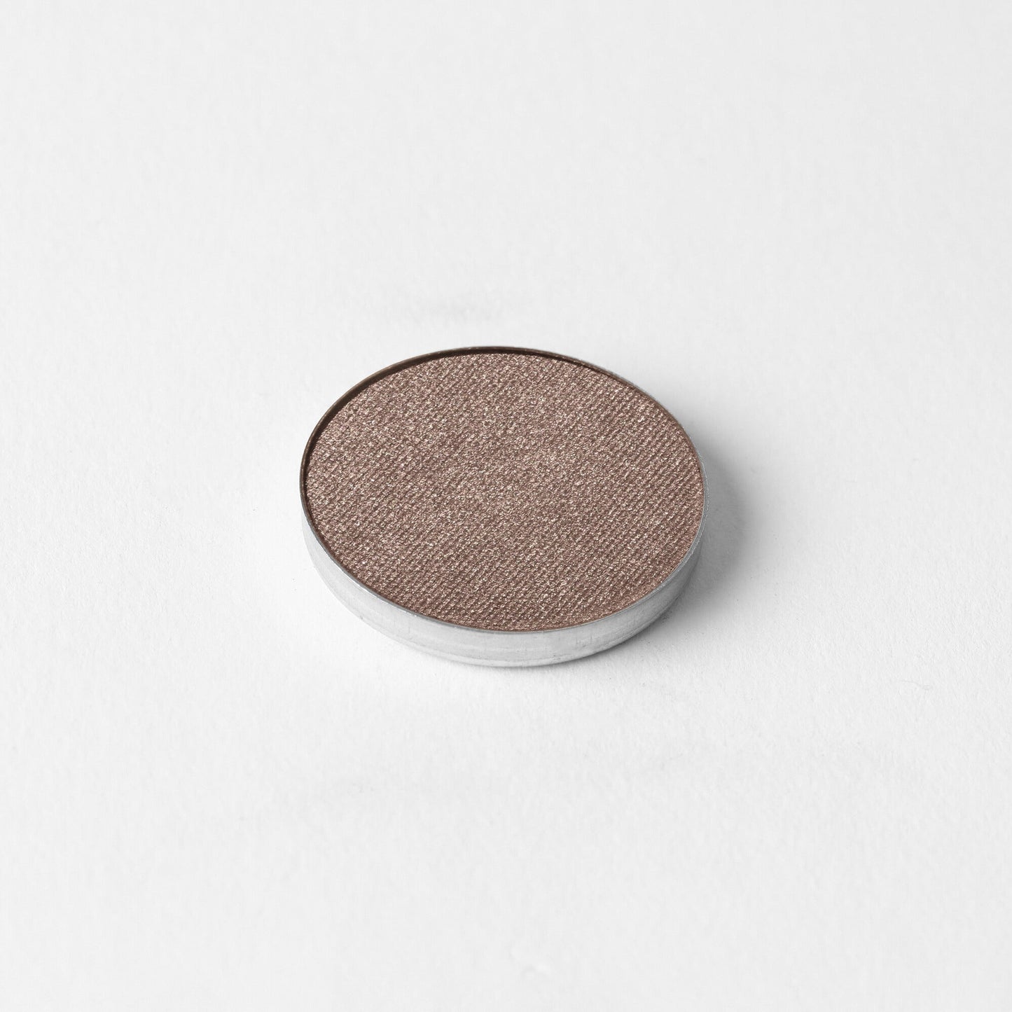 Pressed eyeshadow pan with rose-brown shimmer finish in a round compact
