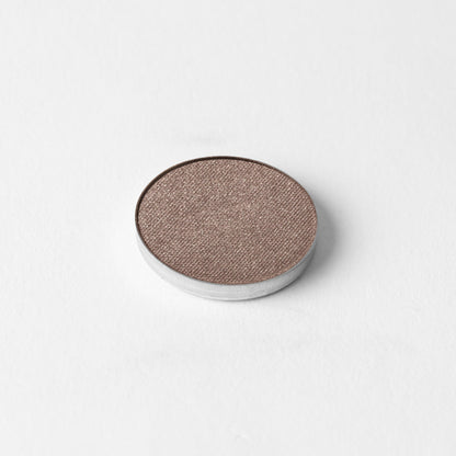 Pressed eyeshadow pan with rose-brown shimmer finish in a round compact