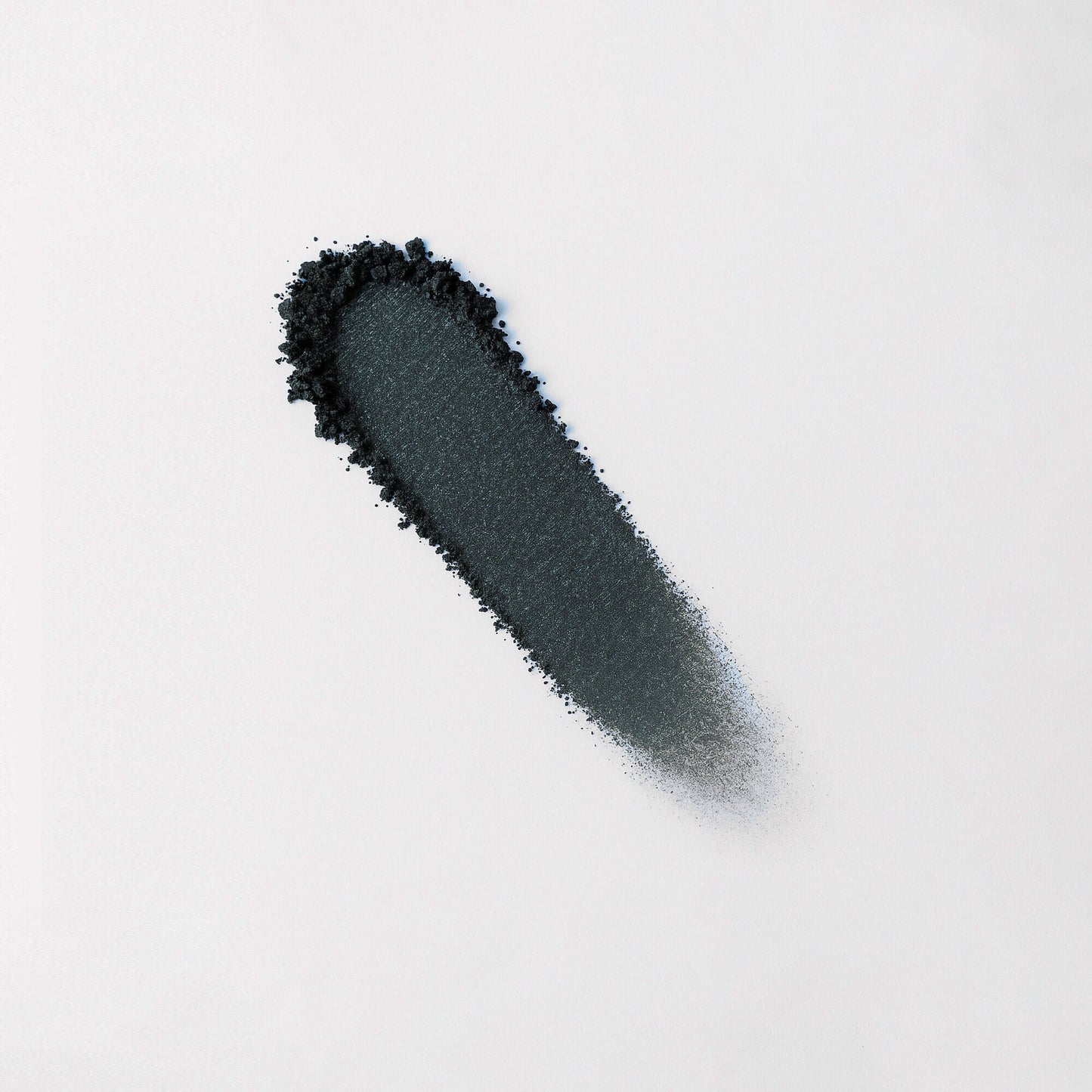 Pressed eyeshadow swatch, charcoal-dark blue shimmer with blurred blended edge.