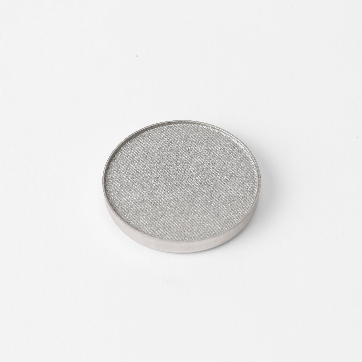 Pressed eyeshadow pan with shimmering light gray color