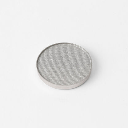 Pressed eyeshadow pan with shimmering light gray color