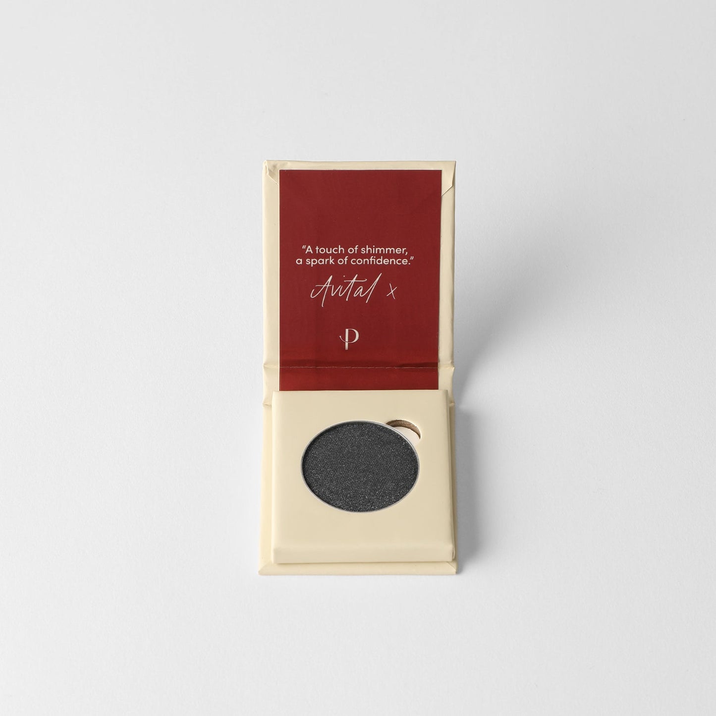 Pressed eyeshadow compact with round pan of dark charcoal shimmer powder.