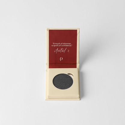 Pressed eyeshadow compact with round pan of dark charcoal shimmer powder.