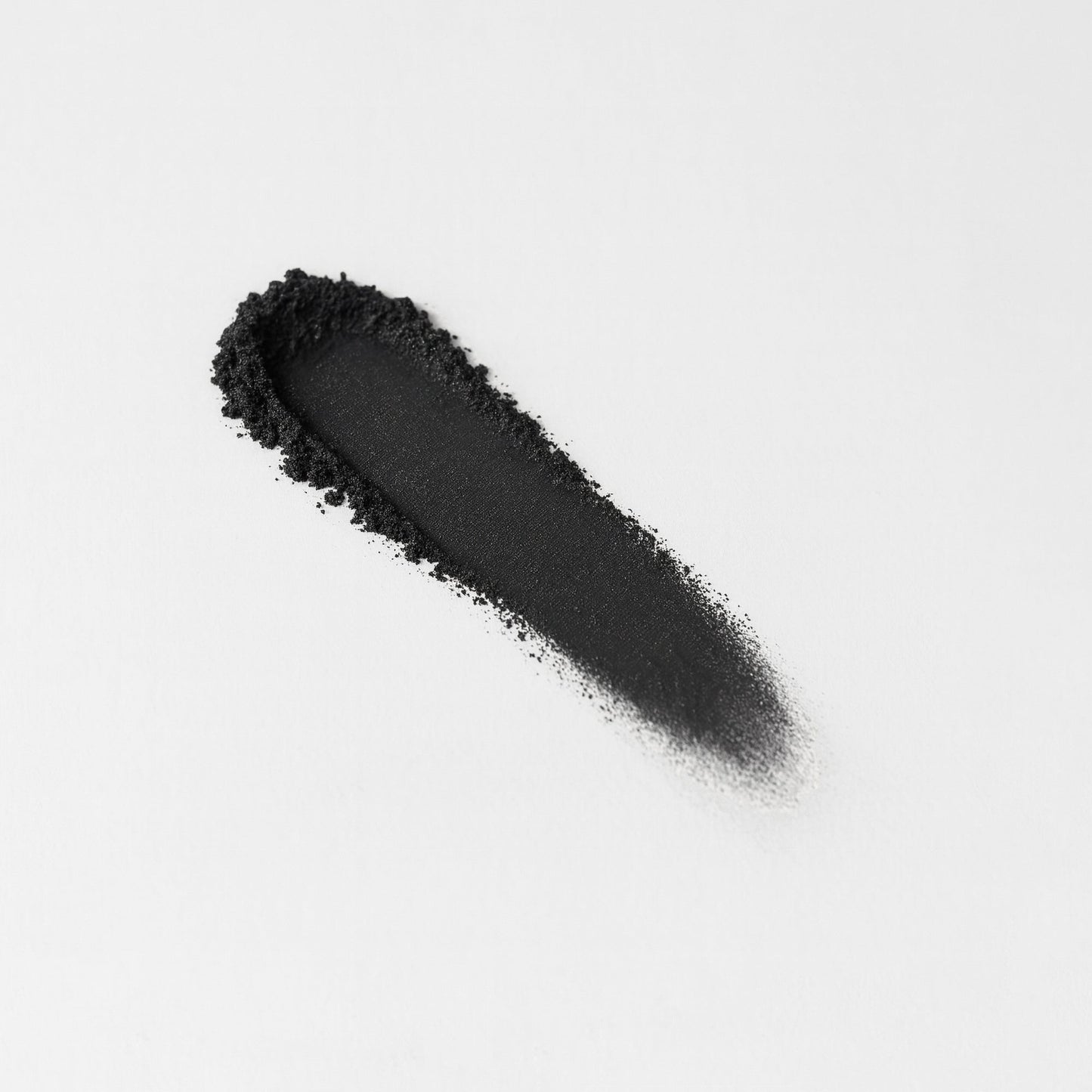 Swatch of dark charcoal pressed eyeshadow, elongated stripe