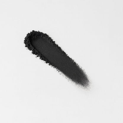 Swatch of dark charcoal pressed eyeshadow, elongated stripe