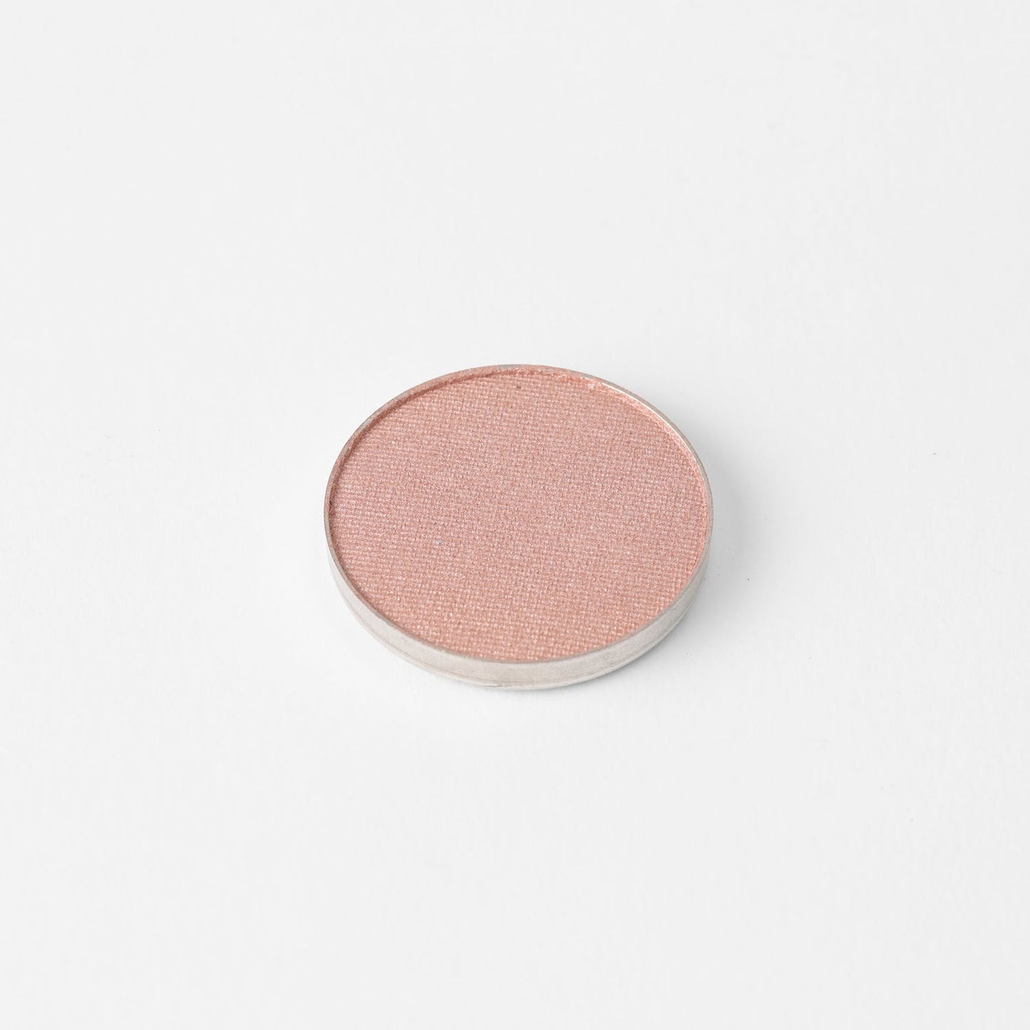 Round pressed eyeshadow pan with soft pink shimmer