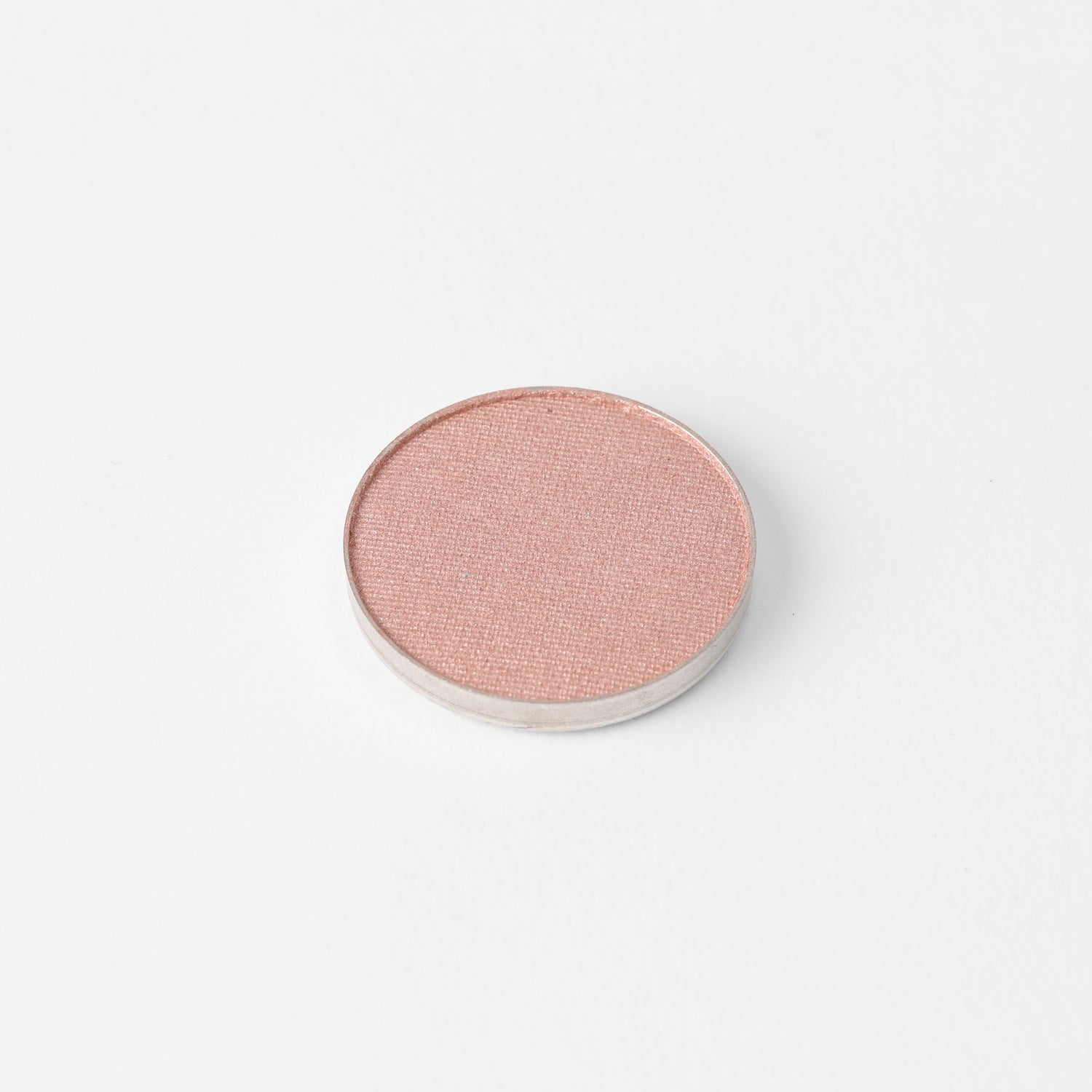 Round pressed eyeshadow pan with soft pink shimmer