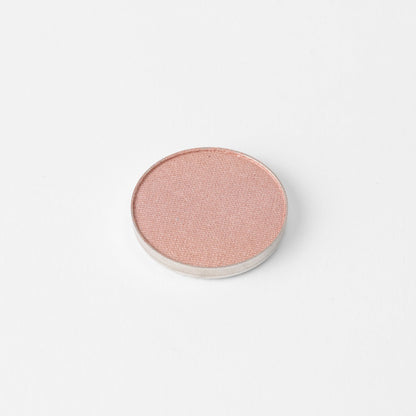 Round pressed eyeshadow pan with soft pink shimmer