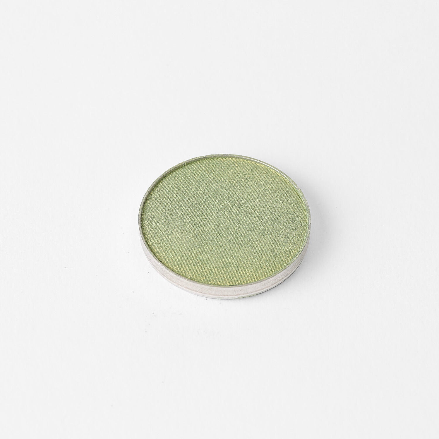 Pressed eyeshadow pan with muted green shade in a round compact.