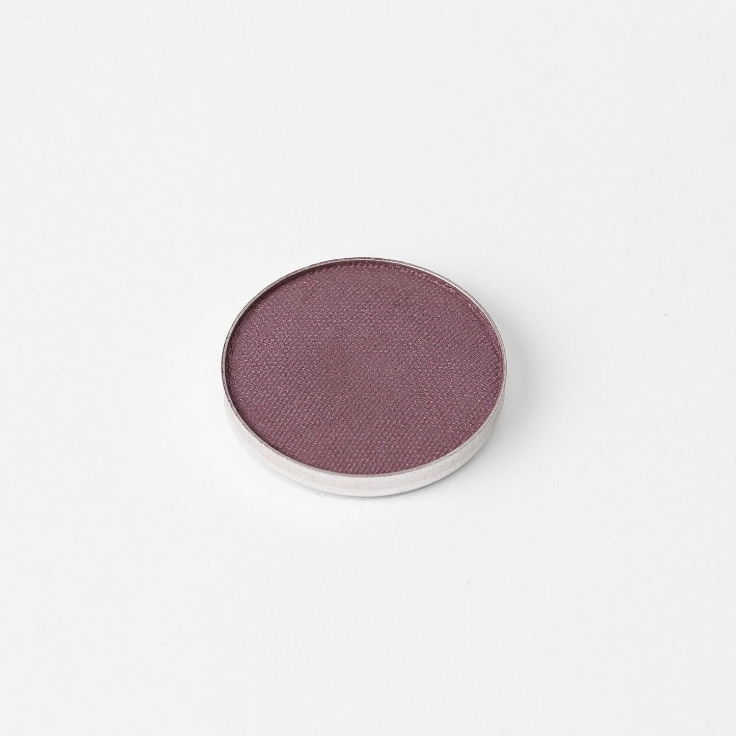 Pressed eyeshadow pan with a smooth purple-mauve shimmer finish in a round case
