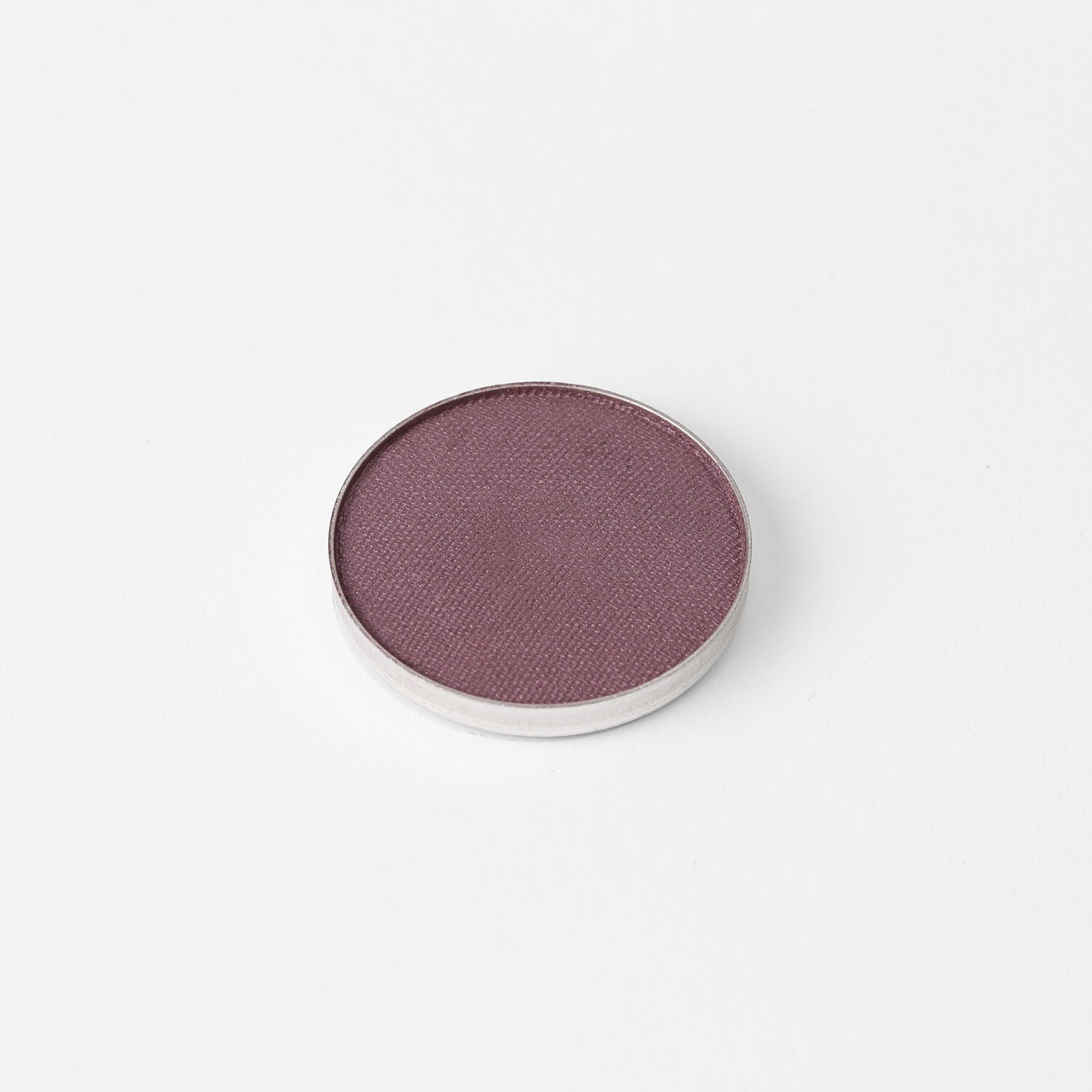 Pressed eyeshadow pan with a smooth purple-mauve shimmer finish in a round case