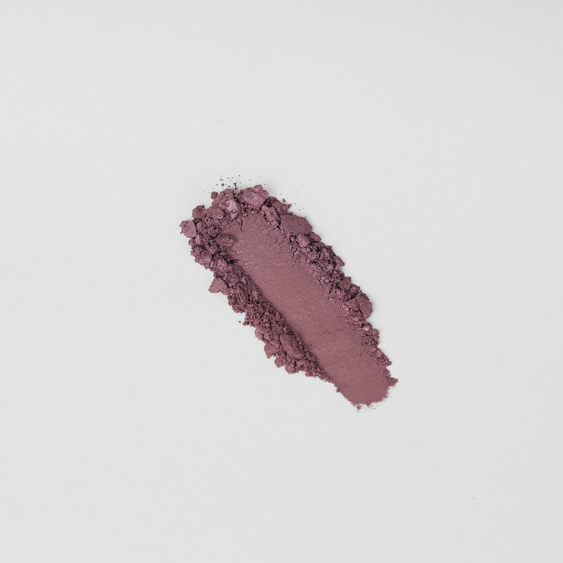 Pressed eyeshadow swatch in rosy purple shimmer with a dusty, blended edge