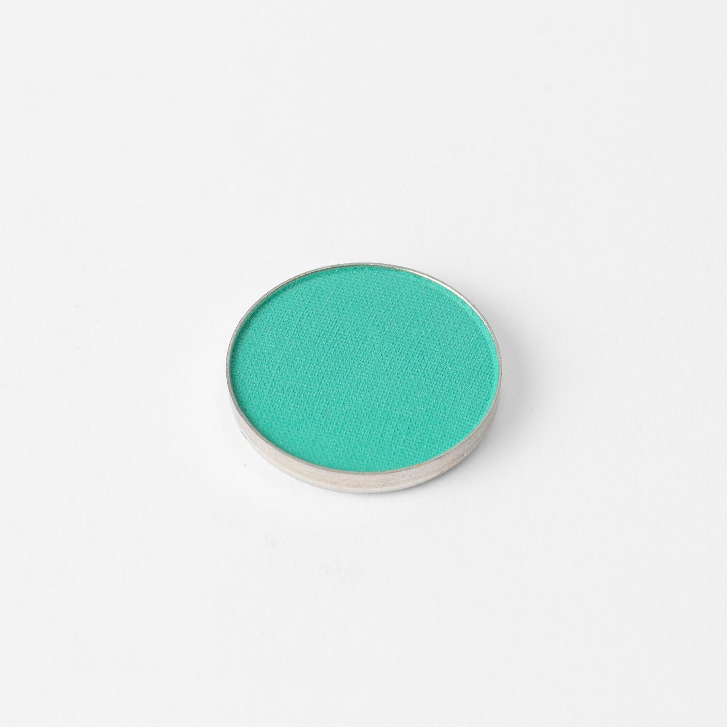 Pressed eyeshadow compact with bright green-teal oval pan