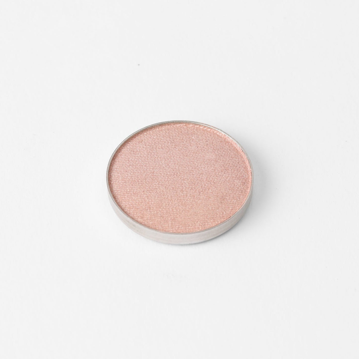 Pressed eyeshadow pan with light pink rose shimmer finish, round compact.