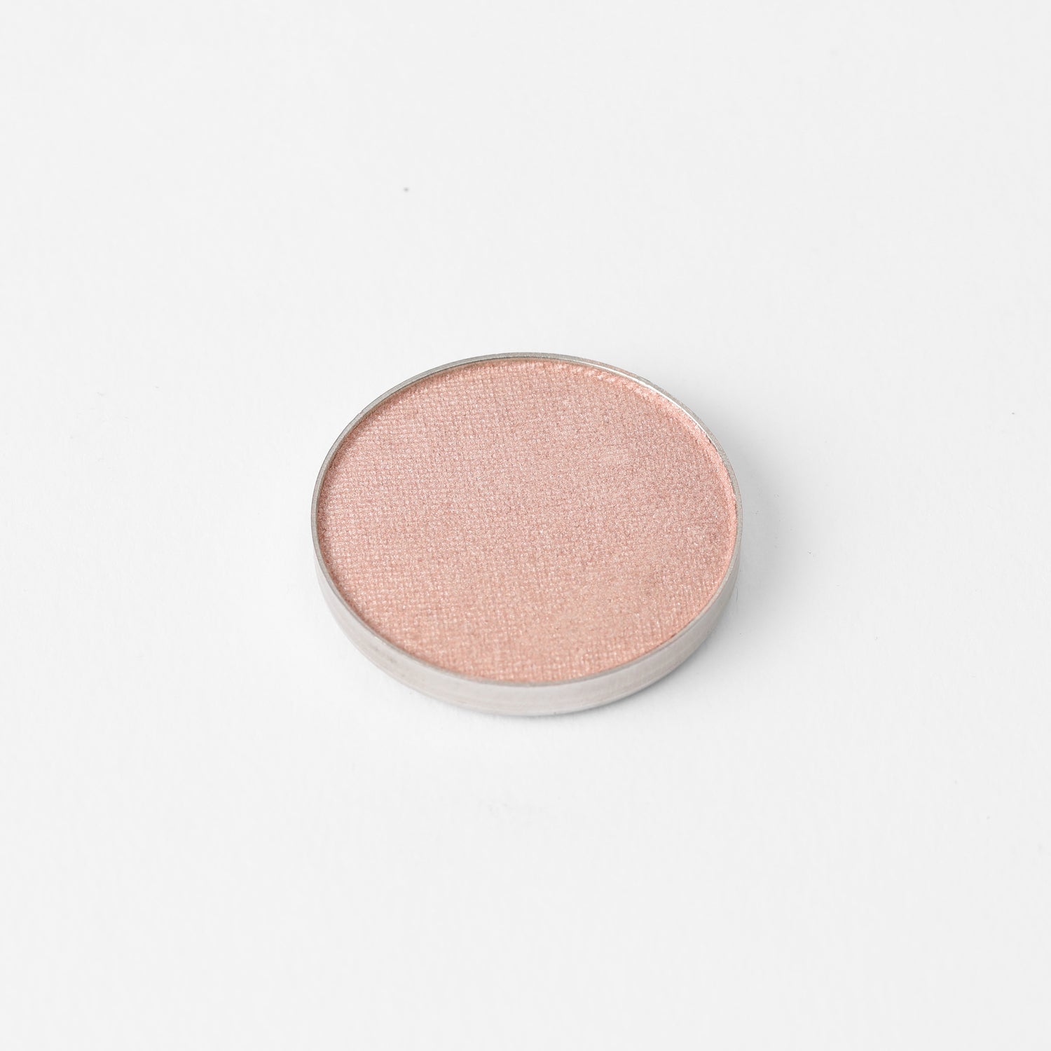 Pressed eyeshadow pan with light pink rose shimmer finish, round compact.
