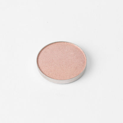 Pressed eyeshadow pan with light pink rose shimmer finish, round compact.