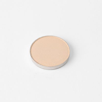 Pressed eyeshadow pan, light beige shimmer finish