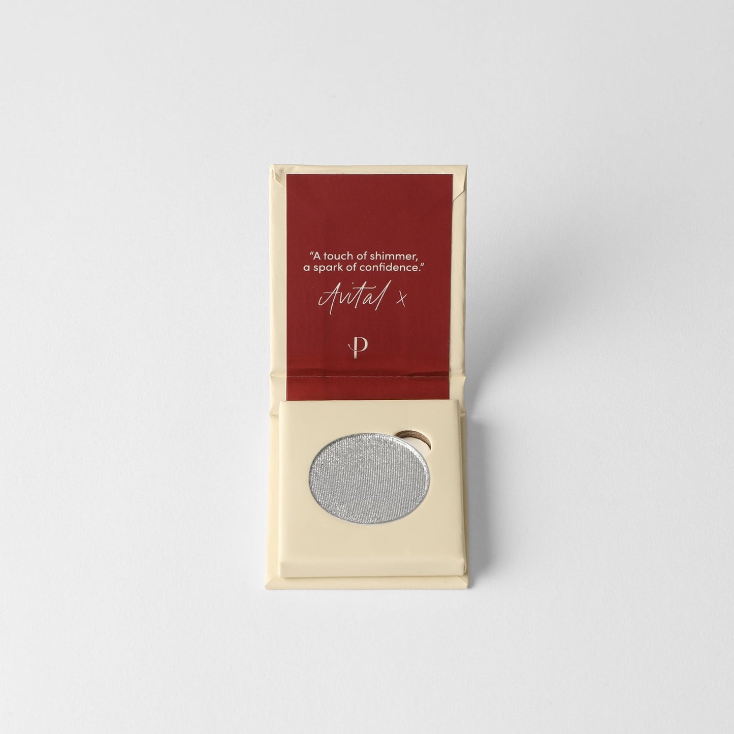 Pressed eyeshadow pan in light gray shimmer, displayed in a cream-colored retail box
